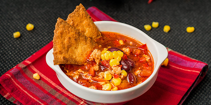 Taco soup in bowl with tortilla chips