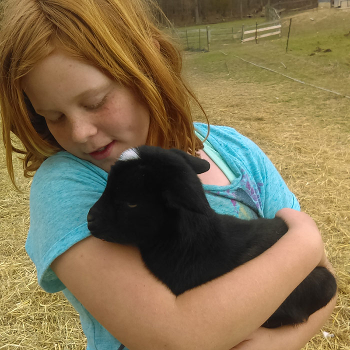 Lilly holding a black baby goat