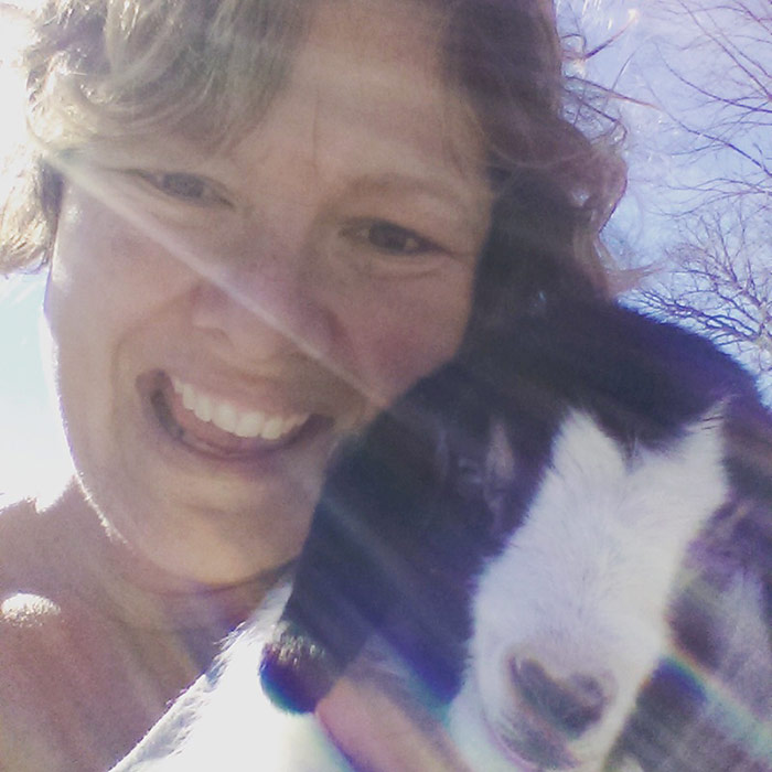 Mackenzie holding a black and white baby goat