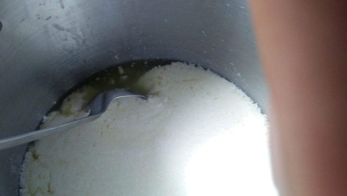 Homemade mozzarella being mixed in sauce pan