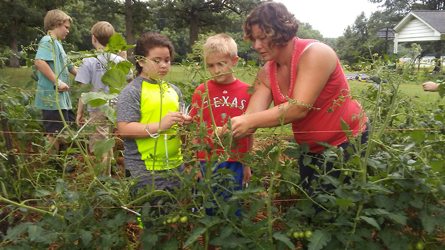 Mackenzie with children harvesting the garden