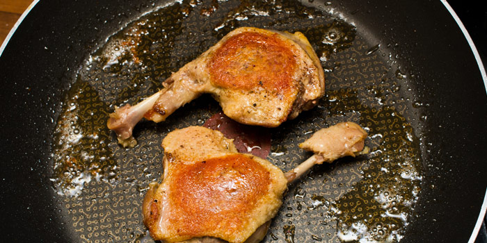 Confit preparation of duck legs in the pan