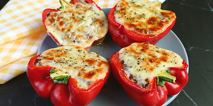 Four Stuffed Red Bell Peppers On A Plate