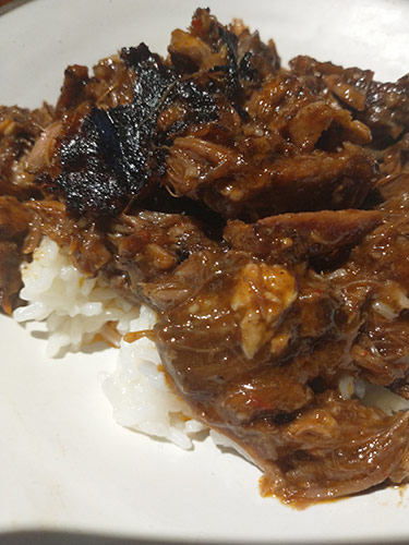 Pulled pork over rice on a plate
