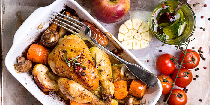 Photo of oven roasted chicken with veggies, garlic, apple, and oil